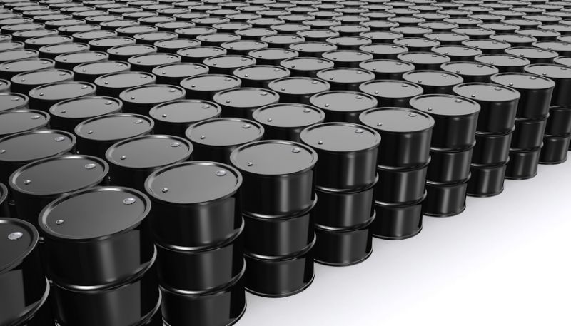 Rows of black oil barrels on a white floor.