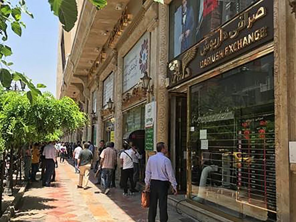 PHOTO: People look at currency deals on the sidewalk of Ferdowsi Street in Tehran, Iran, days after the visit of Japans Prime Minister, Shinzo Abe, June 15, 2019.