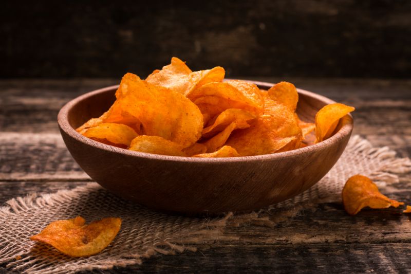 Barbeque potato chips in a wooden bowl.