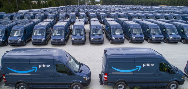 Rows of dozens of Amazon Prime vans, all dark blue with white and light blue logo.