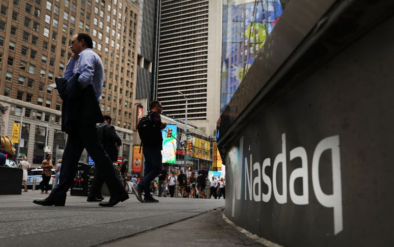 NEW YORK, NY - JULY 30: People walk by the Nasdaq MarketSite in Times Square on July 30, 2018 in New York City. As technology stocks continued their slide on Monday, the Nasdaq Composite dropped 1.1 percent in afternoon trading with shares of Facebook, Netflix, Amazon and Google-parent Alphabet all declining. (Photo by Spencer Platt/Getty Images)