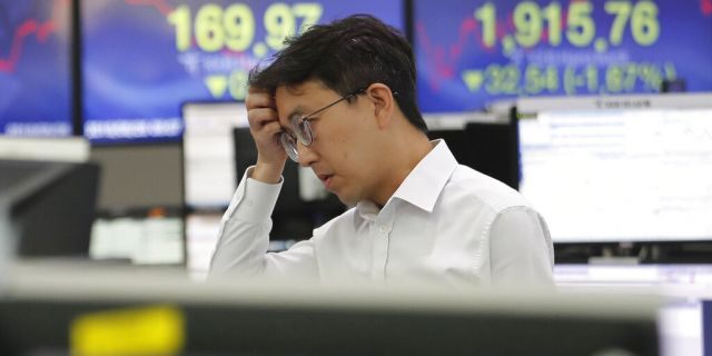 A currency trader watches monitors at the foreign exchange dealing room of the KEB Hana Bank headquarters in Seoul, South Korea, Monday, Aug. 26, 2019. (AP Photo/Ahn Young-joon)