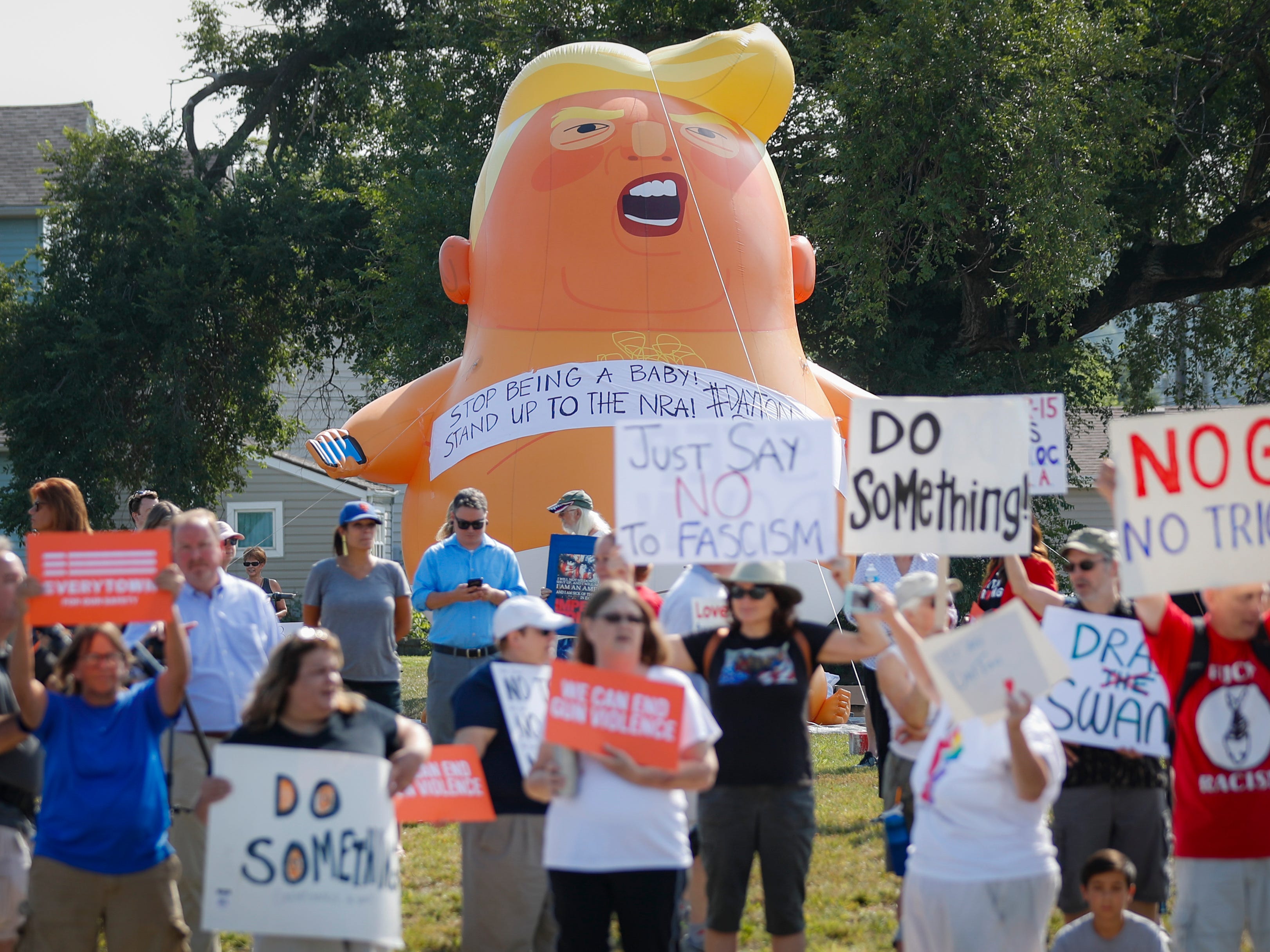 Demonstrators gather to protest the arrival of President Donald Trump outside Miami Valley Hospital after a mass shooting that occurred in the Oregon District early Sunday morning, Wednesday, Aug. 7, 2019, in Dayton. A gunman opened fire in Dayton early Sunday, killing several people including his sister, before officers fatally shot him.