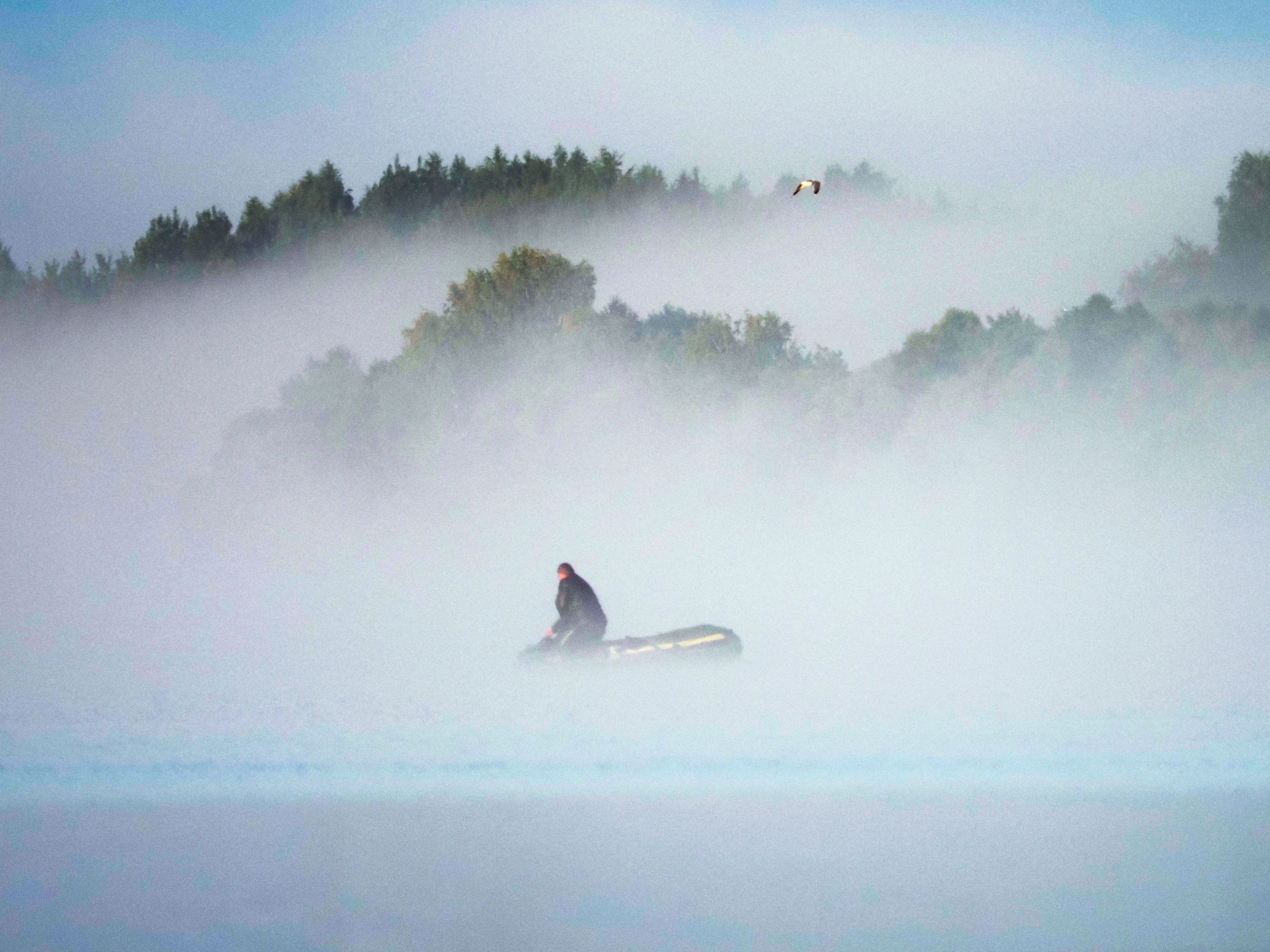 A man sets a fishing net in morning fog near the town of Kalyazin located on the Volga River, north-east of Moscow, Russia on August 7, 2019.