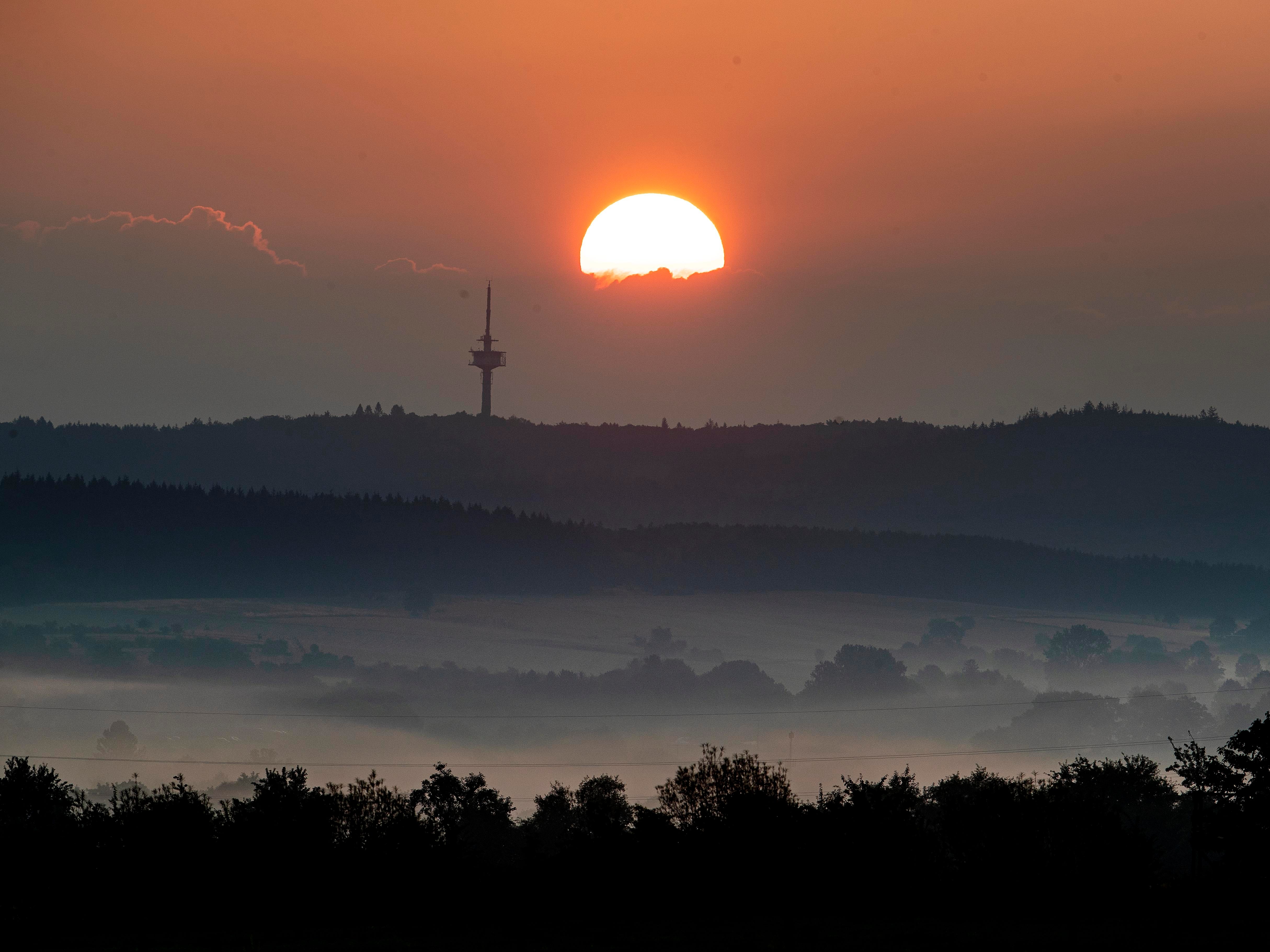 The sun rises in the outskirts of Frankfurt, Germany.