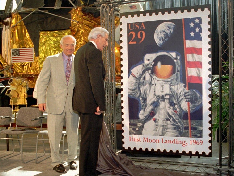 Apollo 11 astronaut Buzz Aldrin, left, and Postmaster General Marvin Runyon, unveil one of two special commemorative stamps celebrating the 25th anniversary of the Apollo 11 lunar landing at The National Air and Space Museum on, July 20, 1994, in Washington. An Apollo 11 lunar landing module is to the left rear.