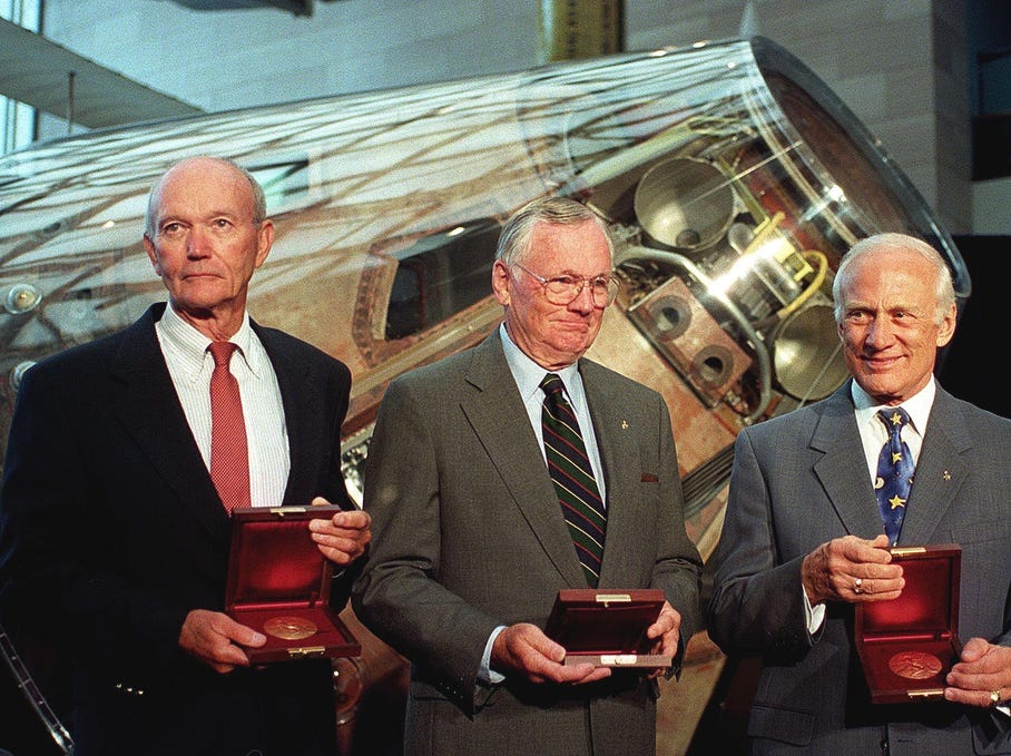 The crew of Apollo 11 Michael Collins (L), Neil Armstrong (C) and Buzz Aldrin stand in front of the Apollo command module Columbia after US Vice President Al Gore awarded them the Samuel P. Langley medal 20 July, 1999 at the National Air and Space Museum in Washington, DC.