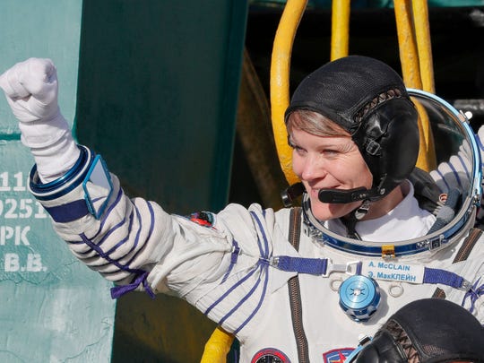 NASA astronaut Anne McClain gestures as she boards the Soyuz MS-11 spacecraft shortly before launch at the Russian-leased Baikonur cosmodrome in Kazakhstan on Dec. 3, 2018.