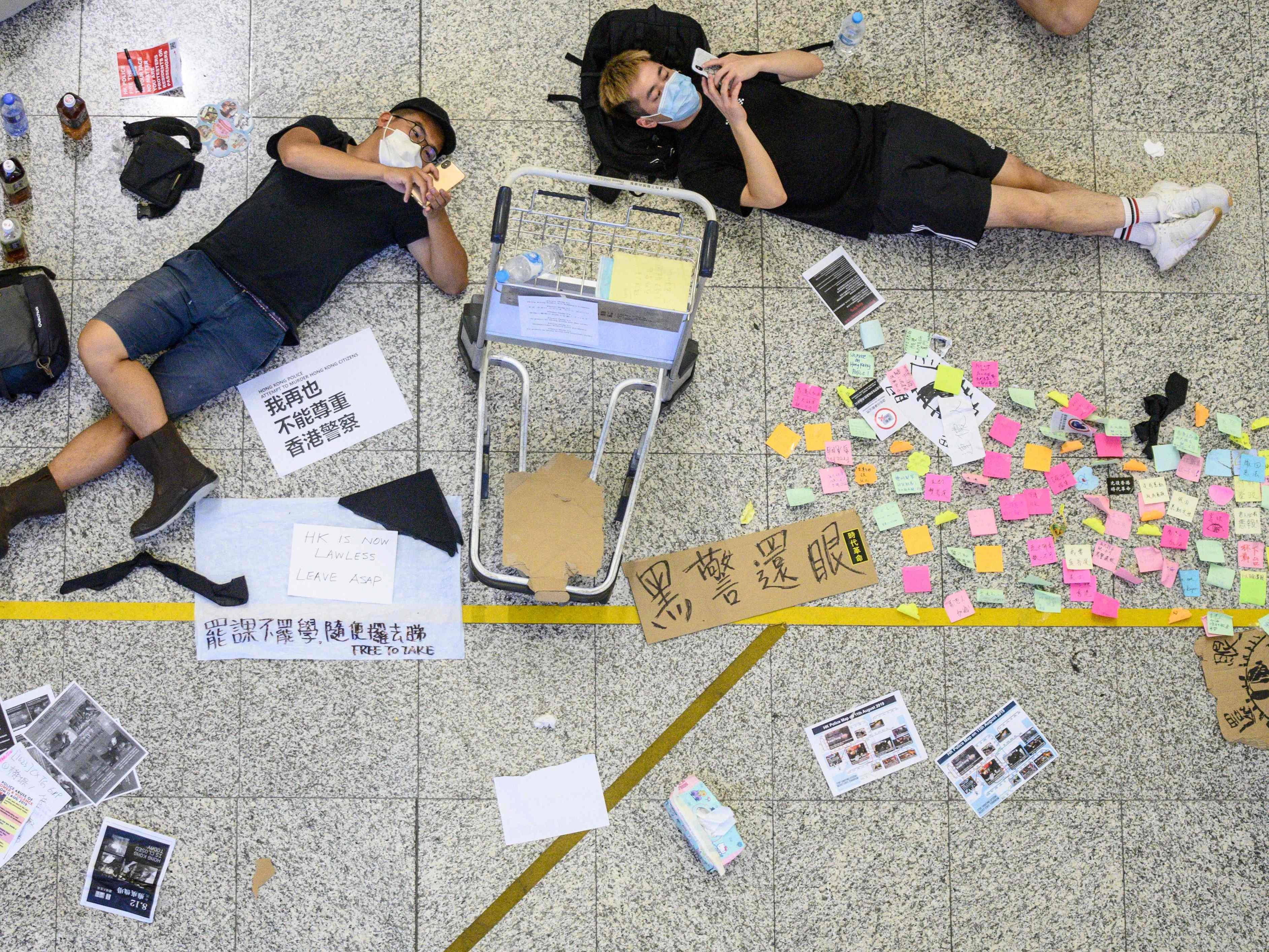 Protesters rest at Hong Kong's International airport during a protest against the police brutality and the controversial extradition bill on August 12, 2019.