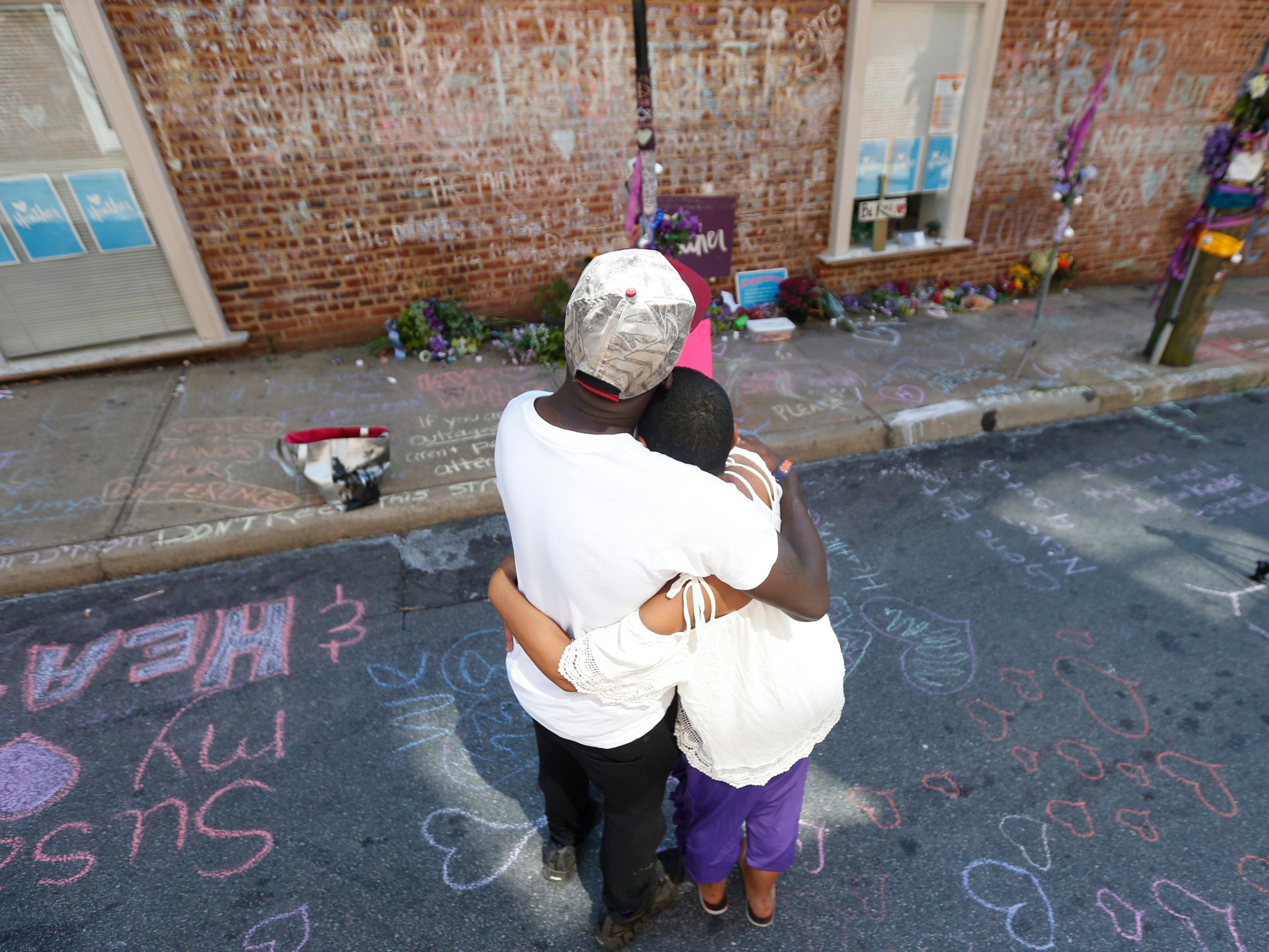 Aaliyah Jones, right, and Kenny Winston, both of Charlottesville, share a moment at the memorial for their friend Heather Heyer's, who died during the Unite the Right rally in 2017 in Charlottesville, Va., on Aug. 12, 2019. 