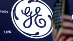 FILE - In this June 26, 2018, file photo the General Electric logo appears above a trading post on the floor of the New York Stock Exchange. General Electric’s stock is tanking after a report which claims the company has been misleading investors. In