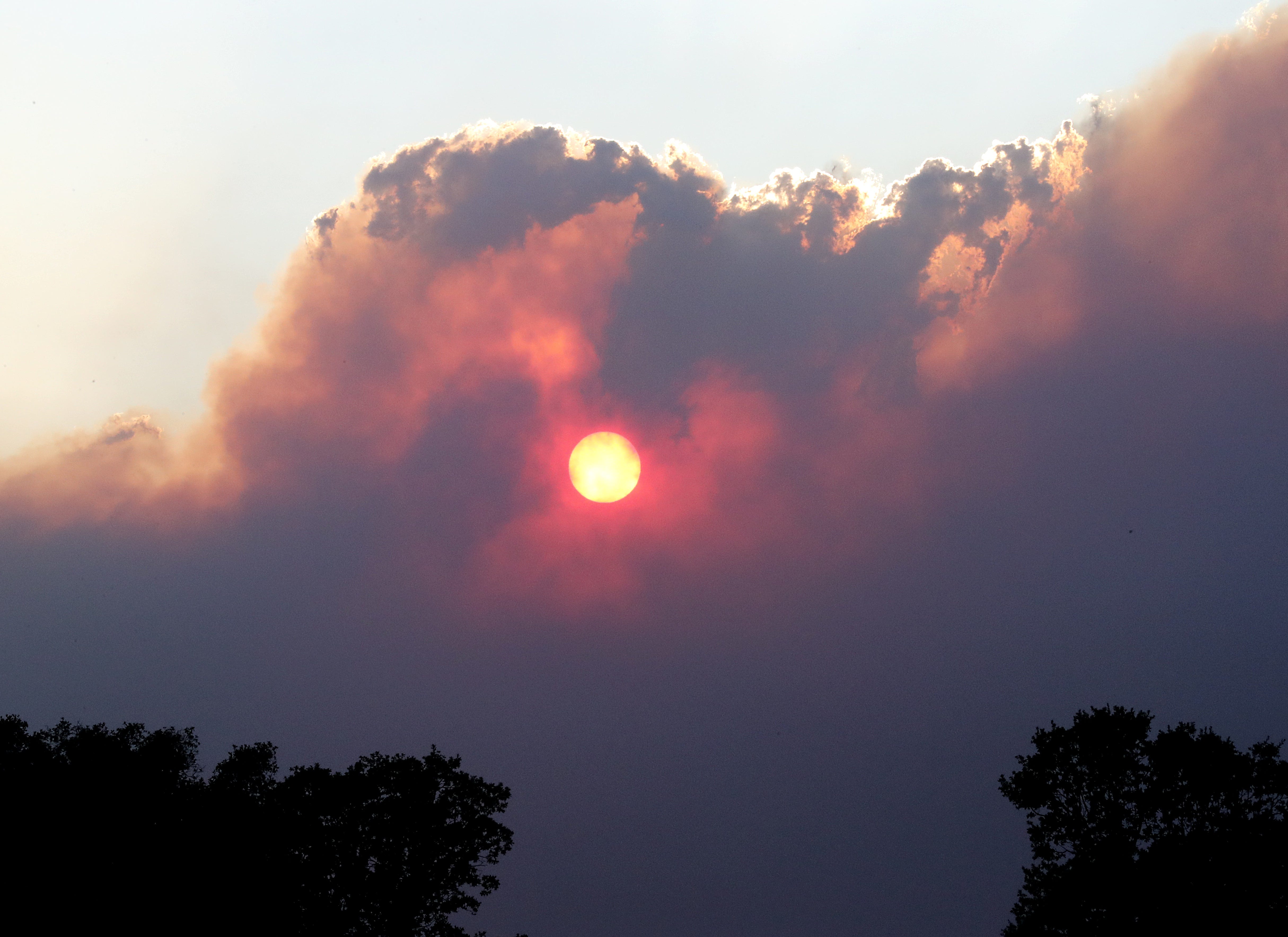 The sun sets through smoke clouds from the Red Bank Fire west of Red Bluff on Sept. 5, 2019.