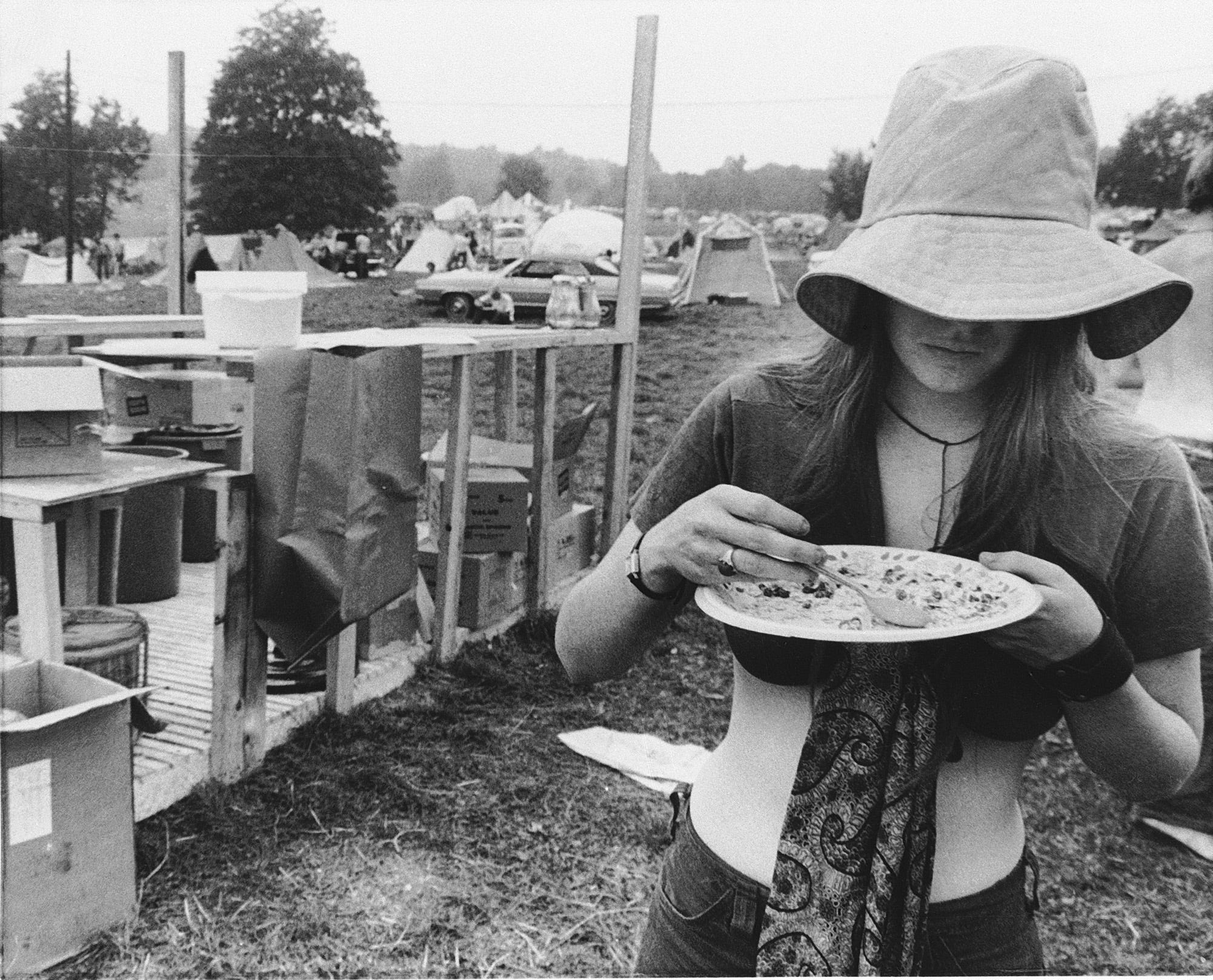 A girl helps herself to a free food ration in the camp area at the Woodstock Music Festival in Bethel, N.Y. on Aug. 15, 1969.