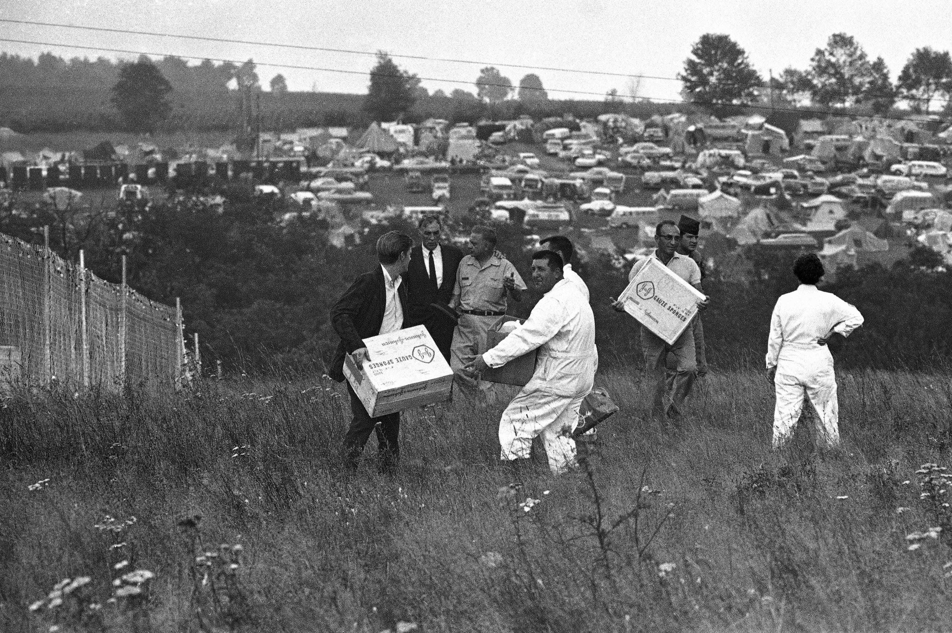 Workers carry medical supplies that arrived by helicopter on the grounds of the Woodstock Music and Art Festival in Bethel, N.Y., Aug. 17, 1969. Helicopters were pressed into service when some 300,000 person attending the festival blocked all roads.