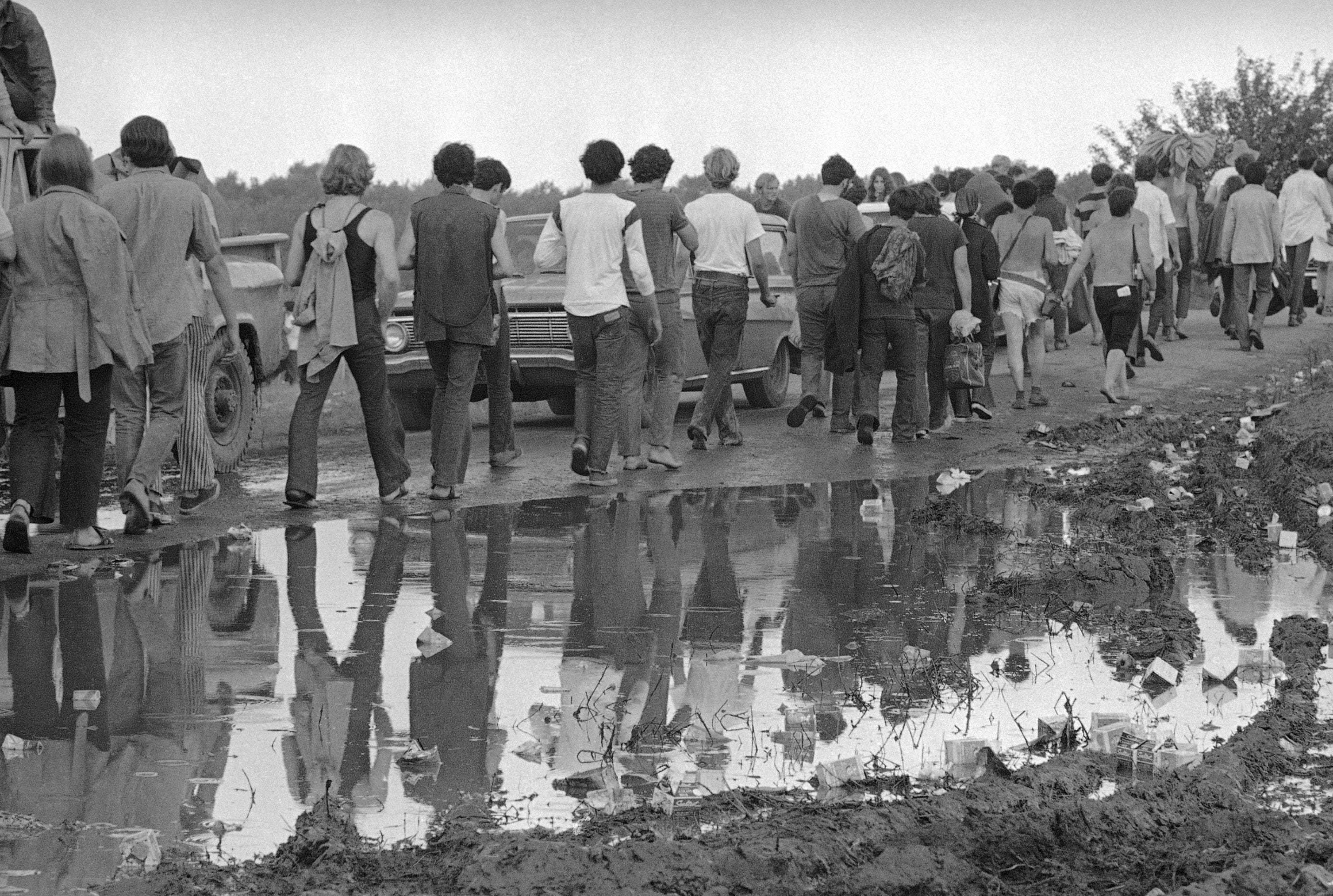 Rock music fans hike from the Woodstock Music and Arts Festival in Bethel, N.Y., Aug. 17, 1969. Some 300,000 fans began to leave as the festival ended in the rain.