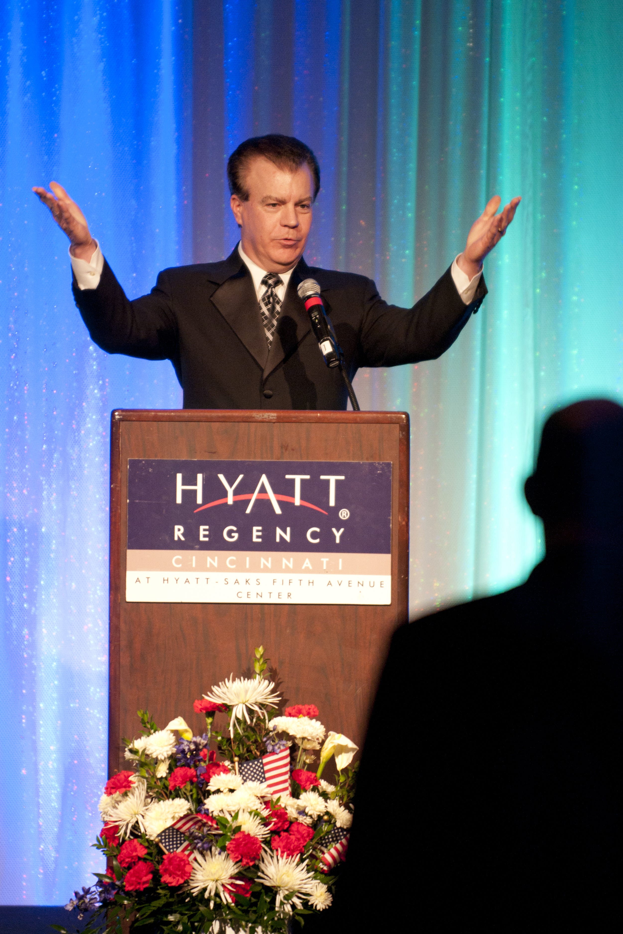 March 12, 2011 STREICHERROAST METRO: Rob Braun, Local 12 News anchor and master of ceremonies, welcomes the guests and motions them to sit down before dinner. A salute, in the form of a dinner and roast, was held Saturday in the Hyatt Regency hotel in the honor of retiring police chief Tom Streicher, March 12, 2011. All of the proceeds from the evening benefited the Friends of Cincinnati Fisher House, which is a foundation where military families can use stay close to a hospitalized family member. (The Enquirer/ Eamon Queeney)