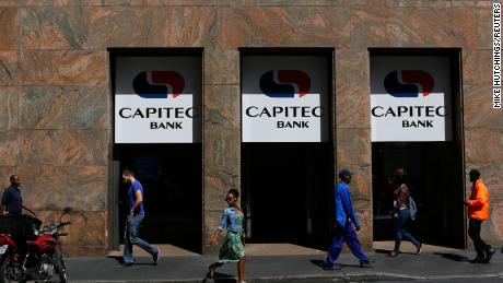 Pedestrians walk past a branch of Capitec Bank in Cape Town.