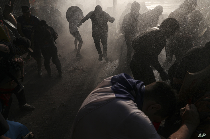 Chilean police clash with anti-government demonstrators in Santiago, Chile, Nov. 12, 2019. 