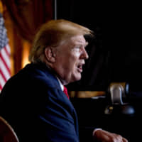 President Donald Trump speaks to the media following a Christmas Eve video teleconference at his Mar-a-Lago estate in Palm Beach, Florida, Dec. 24. As a candidate, Trump repeatedly promised to replace President Barack Obama's health care law with a plan of his own that would provide "insurance for everybody." That has yet to happen.