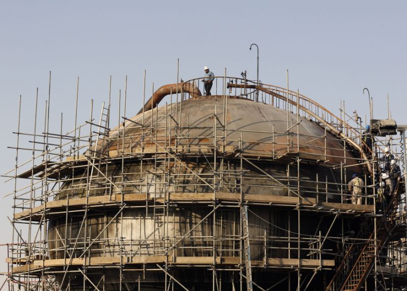 FILE - In this Sept. 20, 2019, file photo, taken during a trip organized by Saudi information ministry, workers fix the damage in Aramco's oil separator at processing facility after the recent Sept. 14 attack in Abqaiq, near Dammam in the Kingdom's Eastern Province. Saudi Arabia formally started its long-anticipated initial public offering of its state-run oil giant Saudi Aramco on Sunday, Nov. 3, 2019, which will see a sliver of the firm offered on a local stock exchange in hopes of raising billions of dollars for the kingdom. (AP Photo/Amr Nabil, File)