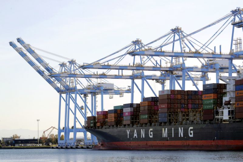 In this Nov. 4, 2019, file photo cargo cranes are used to take containers off of a Yang Ming Marine Transport Corporation boat at the Port of Tacoma in Tacoma, Wash. President Donald Trump says he “will make a decision very soon’’ about whether to impose tariffs on imported cars and auto parts. (AP Photo/Ted S. Warren, File)