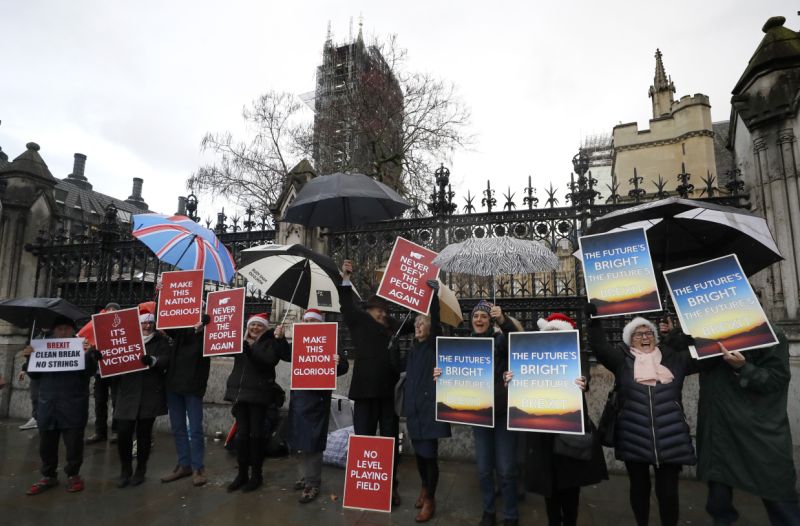 Pro Brexit demonstrators celebrate outside Parliament in London, Friday, Dec. 20, 2019. Members of the British parliament on Friday voted to approve in principle Prime Minister Boris Johnson's Brexit bill, paving the way for Britain to leave the EU next month. (AP Photo/Kirsty Wigglesworth)