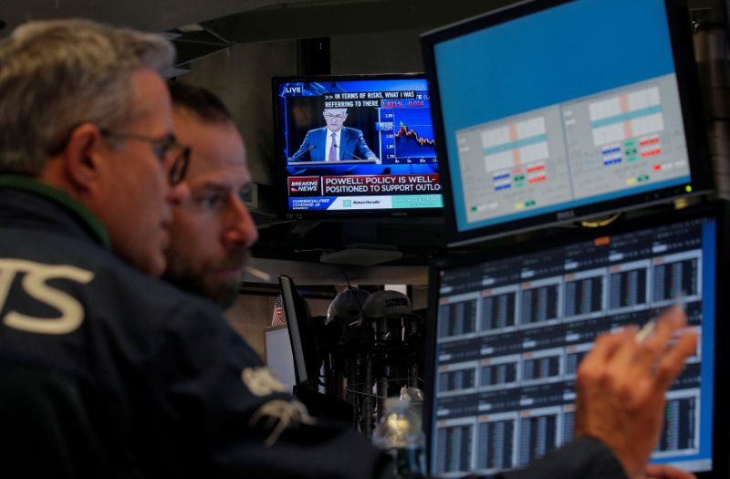 Traders work, as a screen shows Federal Reserve Chairman Jerome Powell's news conference after the U.S. Federal Reserve interest rates announcement, on the floor of the New York Stock Exchange (NYSE) in New York, U.S., October 30, 2019. REUTERS/Brendan McDermid