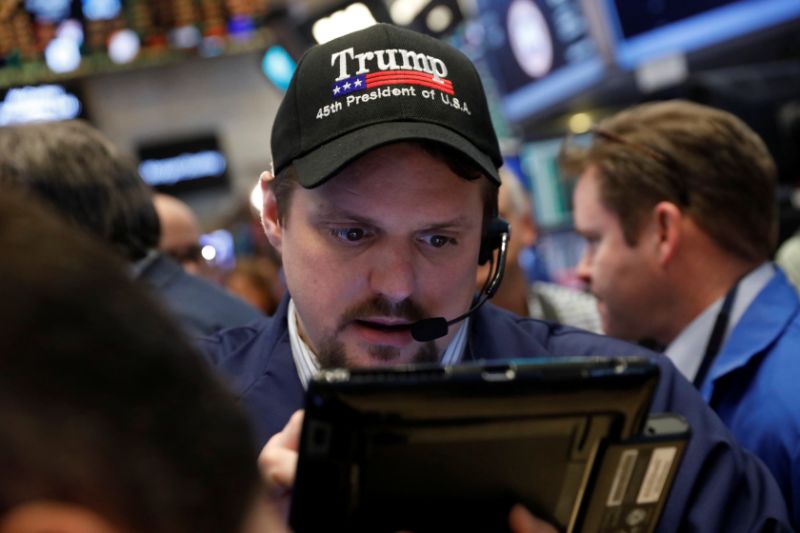 A trader wears a Donald Trump hat while working on the floor of the New York Stock Exchange (NYSE) shortly after the opening bell in New York, U.S., March 16, 2017. REUTERS/Lucas Jackson