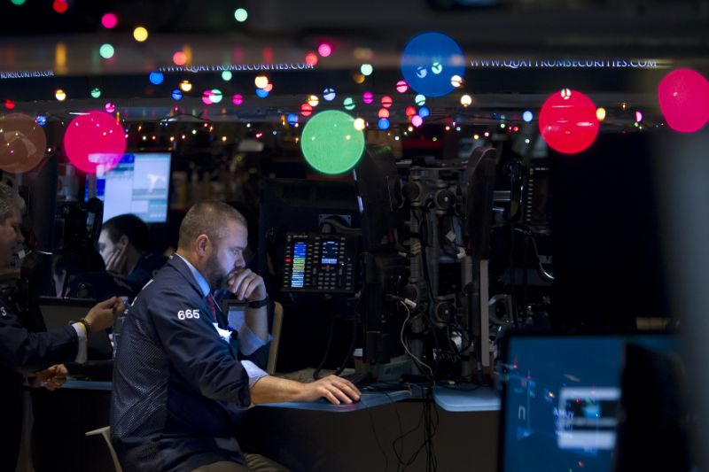 Trader Kevin Lodewick works on the floor of the New York Stock Exchange, which has been decorated with Christmas lights, in New York December 22, 2014. REUTERS/Carlo Allegri (UNITED STATES - Tags: BUSINESS)