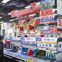 Sales staff urge visitors to replace computers running on Windows 7 with Windows 10 machines at a Yodobashi Camera store in Tokyo on Tuesday.