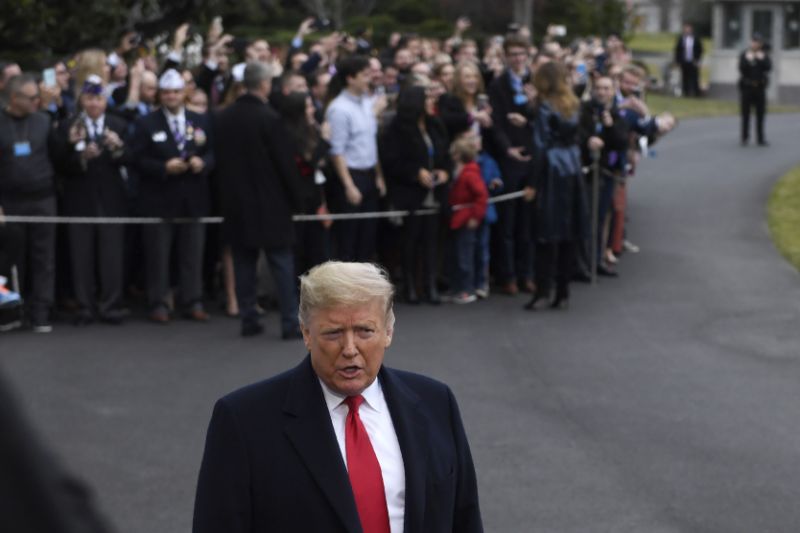 President Donald Trump briefly talks with reporters before boarding Marine One on the South Lawn of the White House in Washington, Monday, Jan. 13, 2020. He, and first lady Melania Trump who is greeting people in the background, are heading to New Orleans to attend the College Football Playoff National Championship between Louisiana State University and Clemson. (AP Photo/Susan Walsh)