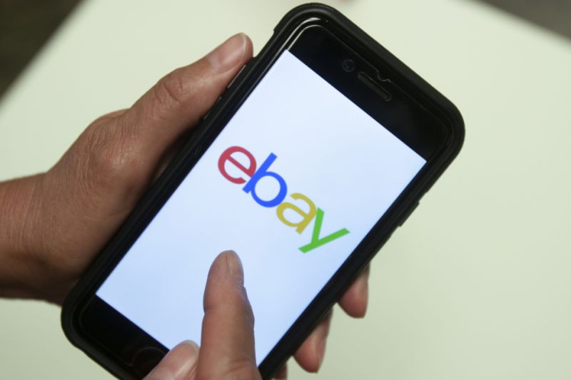 FILE - In this July 11, 2019, file photo, an Ebay app is shown on a mobile phone in Miami. Britain's competition watchdog said Wednesday, Jan. 8, 2020 that Facebook and eBay pledged to crack down on the trade in fake reviews at its request, removing hundreds of accounts, pages and groups involved in the illicit business. (AP Photo/Wilfredo Lee, File)