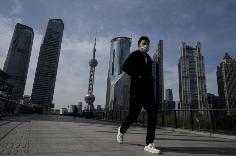 A man wearing a protective face mask walks on an overpass in Lujiazui financial district in Shanghai on February 10, 2020. - The death toll from the novel coronavirus surged past 900 in mainland China on February 10, overtaking global fatalities in the 2002-03 SARS epidemic, even as the World Health Organization said the outbreak appeared to be stabilising. (Photo by NOEL CELIS / AFP) (Photo by NOEL CELIS/AFP via Getty Images)