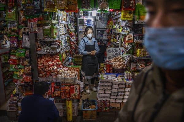 A Beijing shopkeeper waiting for customers this month.