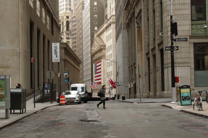 A woman walks on a nearly empty street near the New York Stock Exchange (NYSE) in New York, U.S., March 18, 2020. REUTERS/Lucas Jackson