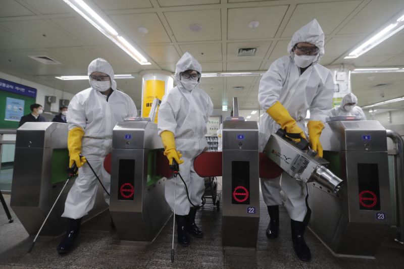 Workers wearing protective gears spray disinfectant as a precaution against the new coronavirus at a subway station in Seoul, South Korea, Friday, Feb. 28, 2020. Japan's schools prepared to close for almost a month and entertainers, topped by K-pop superstars BTS, canceled events as a virus epidemic extended its spread through Asia into Europe and on Friday, into sub-Saharan Africa. (AP Photo/Ahn Young-joon)