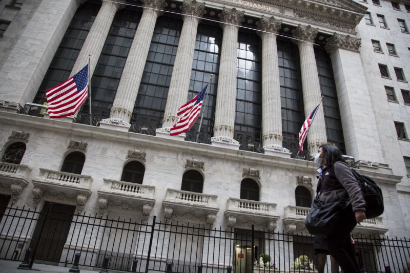 NEW YORK, NY - MARCH 12: A woman wearing a protective mask walks past the New York Stock Exchange on March 12, 2020. in New York City. The Dow Jones industrial average fell 2,352.60 points, a decrease of almost 10% and the largest since 1987. (Photo by Pablo Monsalve/VIEWpress/Corbis via Getty Images)