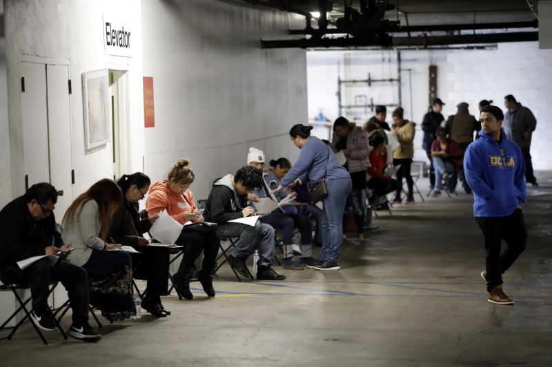 FILE - In this March 13, 2020 file photo, unionized hospitality workers wait in line in a basement garage to apply for unemployment benefits at the Hospitality Training Academy in Los Angeles. More than 6.6 million Americans applied for unemployment benefits last week, far exceeding a record high set just last week, a sign that layoffs are accelerating in the midst of the coronavirus. (AP Photo/Marcio Jose Sanchez, File)