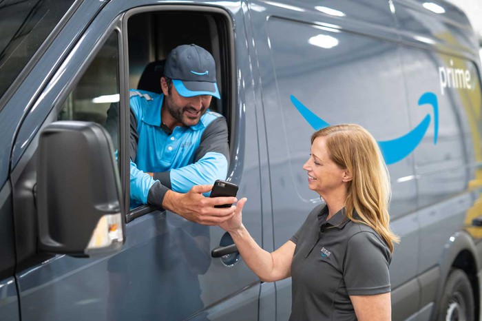 An Amazon delivery driver checks an order.