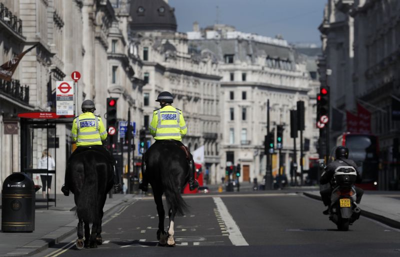 Mounted police officers patrol along a deserted Regent Street in London, as the country is in lockdown to help curb the spread of the coronavirus, Wednesday, April 15, 2020. Experts in the UK have warned that the economy could shrink by up to 35% as a knock on effect of the lockdown. The highly contagious COVID-19 coronavirus has impacted on nations around the globe, many imposing self isolation and exercising social distancing when people move from their homes. (AP Photo/Frank Augstein)