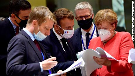 Spain&#39;s Prime Minister Pedro Sanchez (left), French President Emmanuel Macron (center) and German Chancellor Angela Merkel (right) looking at documents during the EU summit in Brussels on Monday.