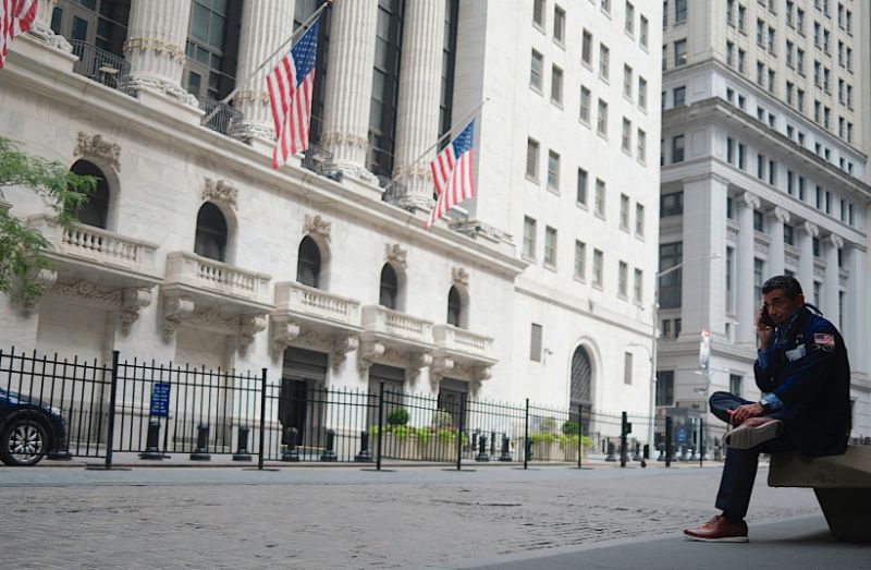 A trader makes a phone call outside the New York Stock Exchange (NYSE) on July 20, 2020 at Wall Street in New York City. - Wall Street stocks were mixed early July, 20, 2020 as markets awaited congressional debate on another round of stimulus spending and major earnings releases later in the week. (Photo by Johannes EISELE / AFP) (Photo by JOHANNES EISELE/AFP via Getty Images)