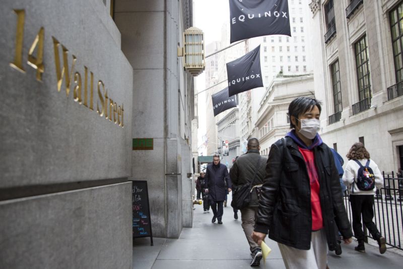 NEW YORK, NY - MARCH 12: A woman wearing a protective mask walks past the New York Stock Exchange on March 12, 2020. in New York City. The Dow Jones industrial average fell 2,352.60 points, a decrease of almost 10% and the largest since 1987. (Photo by Pablo Monsalve/VIEWpress/Corbis via Getty Images)