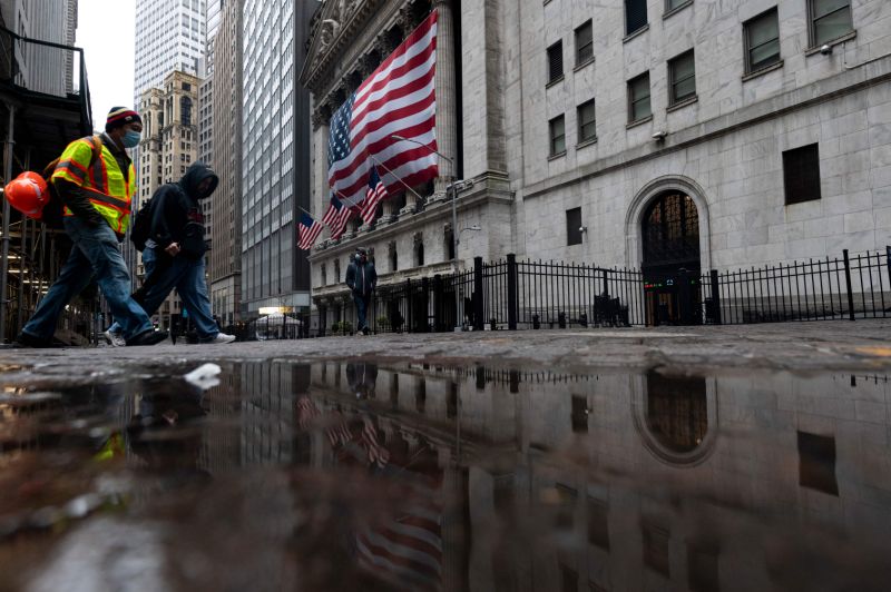 Two men wearing a masks walks pass the New York Stock Exchange (NYSE) on April 30, 2020 in New York City. - Wall Street stocks opened lower Thursday following another spike of jobless claims in the wake of coronavirus shutdowns, offsetting strong results from tech giants. Another 3.84 million US workers filed for unemployment benefits last week and the total has now passed 30 million in six weeks, according to the Labor Department data. (Photo by Johannes EISELE / AFP) (Photo by JOHANNES EISELE/AFP via Getty Images)