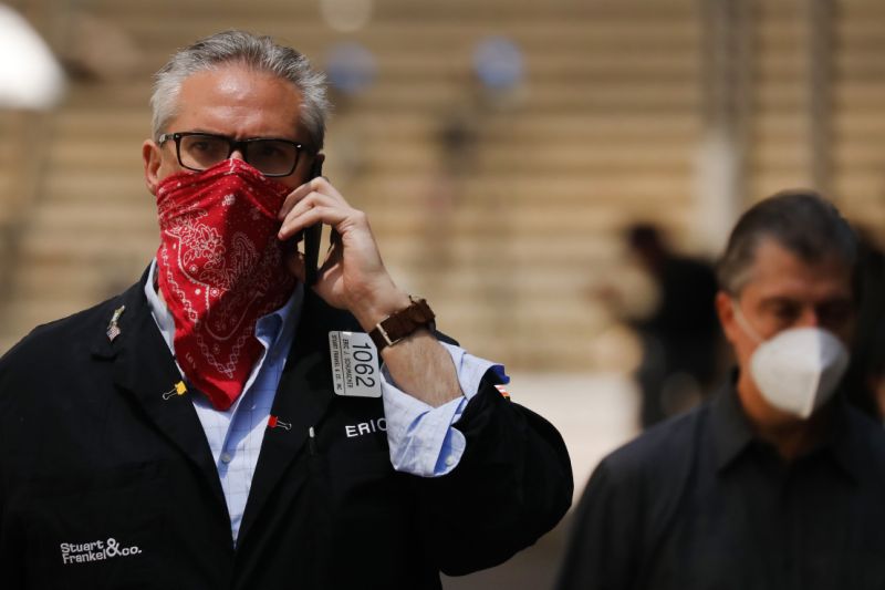 NEW YORK, NEW YORK - MAY 26: A trader walks by the New York Stock Exchange (NYSE) on the first day that traders are allowed back onto the historic floor of the exchange on May 26, 2020 in New York City. While only a small number of traders will be returning at this time, those that do will have to take temperature checks and wear face masks at all times while on the floor. The Dow rose over 600 points in morning trading as investors see economic activity in America picking up (Photo by Spencer Platt/Getty Images)