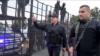 Belarusian President Alyaksandr Lukashenka, armed with a Kalashnikov-type rifle, greets riot-police officers near the Palace of Independence in Minsk amid massive opposition protests on August 23.