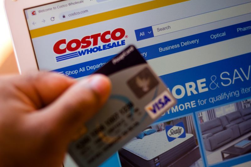 BRAZIL - 2020/07/05: The Costco Wholesale Corporation website is displayed on a laptop in the background with a hand holding a bank card. (Photo Illustration by Rafael Henrique/SOPA Images/LightRocket via Getty Images)